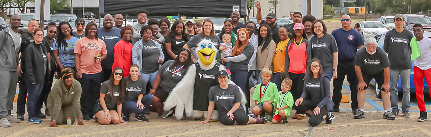 Group of Pelican employees posing with Petey the Pelican