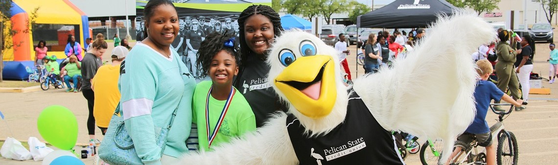 Members posing with Petey Pelican at a kids' event