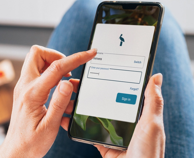 A person tapping the login section of the MyPelican mobile app on their smartphone.