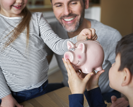 two kids posing with their piggy bank